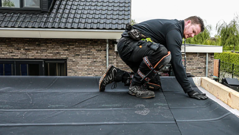 Foto van dakdekker die EPDM dakbedekking plaatst