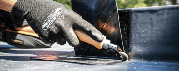 EPDM op maat snijden Afbeelding van een dakdekker die een EPDM dak maakt